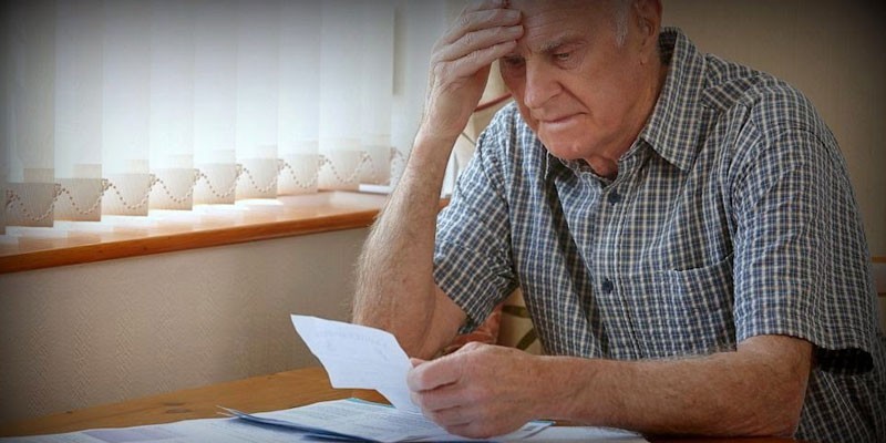 Пожилой мужчина изучает документ